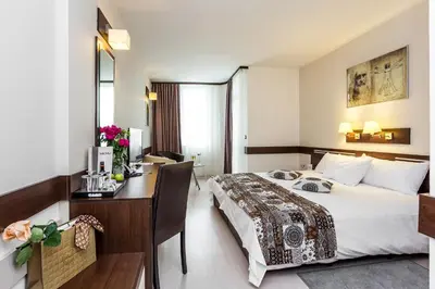 a hotel room with a bed and a desk at Grami Hotel Sofia in Sofia