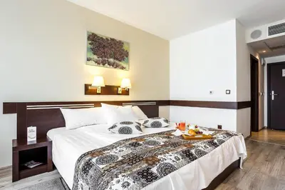 a bedroom with a bed with a tray of food on it at Grami Hotel Sofia in Sofia