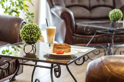 a table with a piece of cake and a drink on it at Grami Hotel Sofia in Sofia