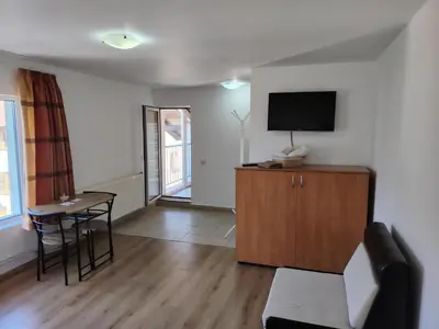 a living room with a tv and a table at Guest House Lila in Bansko