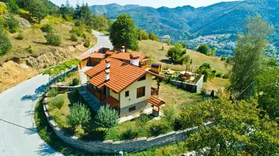 a house on a hill next to a road at Villa Rupcovoto in Smolyan