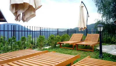 two wooden chairs and a street light next to a fence at Villa Rupcovoto in Smolyan