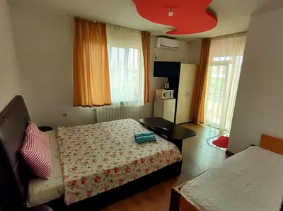 a bedroom with a bed and a couch and a table at Къща за гости 