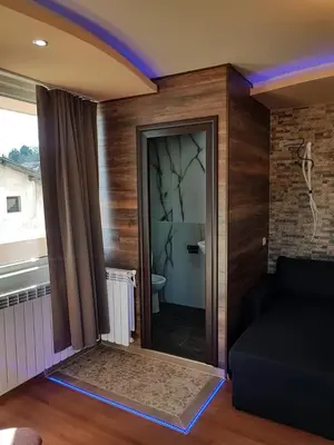 a living room with a couch and a glass door at Къща за гости 