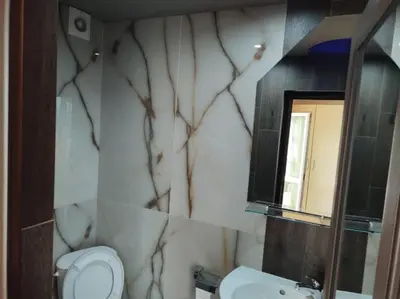 a bathroom with a toilet and a sink and a mirror at Къща за гости 