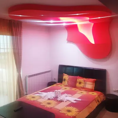 a bedroom with a bed with a red ceiling at Къща за гости 