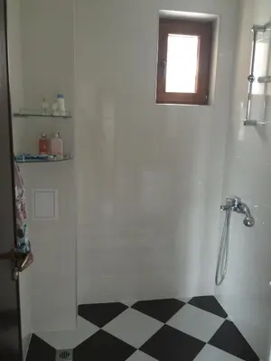 a bathroom with a shower and a checkered floor at Apartment Spa Holidays in Sandanski