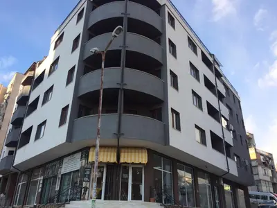 a tall white building with a spiral at Apartment Spa Holidays in Sandanski