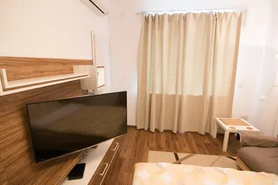 a living room with a large flat screen tv at Sunshine Sofia in Sofia