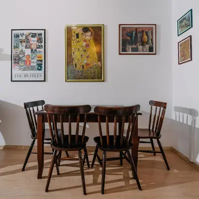 a table with four chairs and a painting on the wall at Veli Hills Apartments in Velingrad
