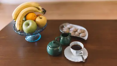 a bowl of fruit and a cup of coffee on a table at Veli Hills Apartments in Velingrad
