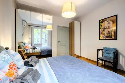 a bedroom with a large bed with a blue blanket at Casa Dolce Far Niente, 2BATH&2BED, PARKING, Vitosha blvd in Sofia