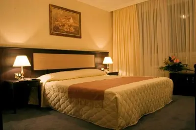a hotel room with a large bed and two lamps at Alex Apartment Sofia in Sofia