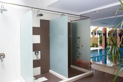 a bathroom with a glass shower with a pool at Alex Apartment Sofia in Sofia