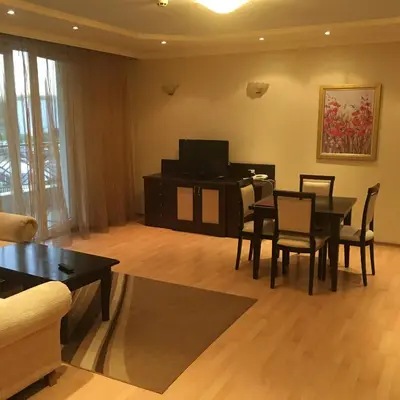 a living room with a dining table and a tv at Alex Apartment Sofia in Sofia