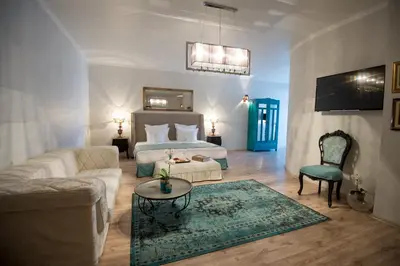a living room with a bed and a couch and a table at Hotel Tempo Boutique in Pazardzhik