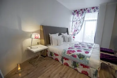 a bedroom with a bed with a lamp and a window at Hotel Tempo Boutique in Pazardzhik
