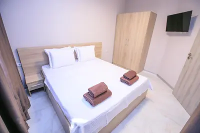 a bedroom with a bed with two towels on it at Apartments KiM Sandanski in Sandanski