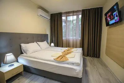 a hotel room with a bed with a towel on it at Apartments KiM Sandanski in Sandanski