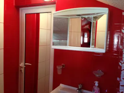 a bathroom with red walls and a mirror and a sink at Guest House Lori in Teteven