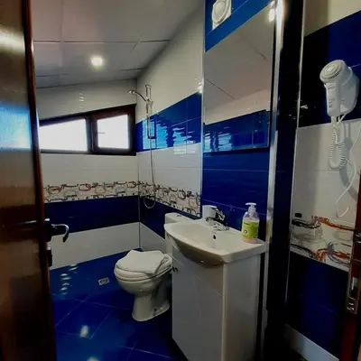 a blue and white bathroom with a toilet and a sink at Къща за гости Мурите in Sapareva Banya