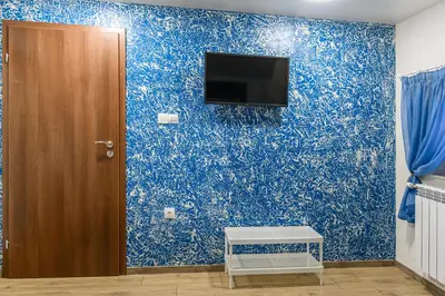 a room with a blue wall with a tv on it at Къща за гости Мурите in Sapareva Banya