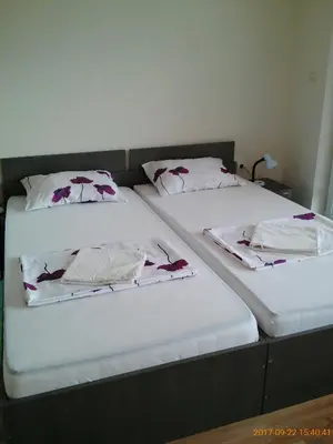 two beds with white sheets and flowers on them at Vila Bachkovo in Bachkovo