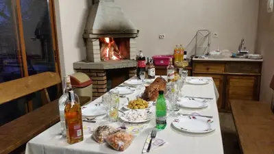 a table with food and a fireplace in a kitchen at Kavdanski Guesthouse in Sapareva Banya