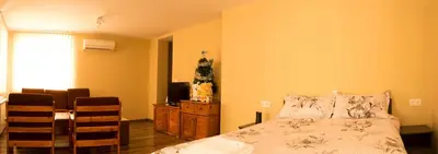 a bedroom with a bed and a table and a television at Kavdanski Guesthouse in Sapareva Banya