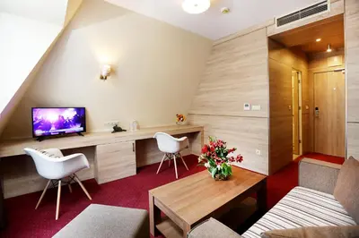 a living room with a tv and a table and chairs at Hotel COOP, Sofia in Sofia