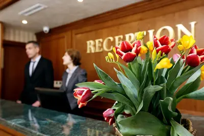 a vase of red and yellow tulips on a table at Hotel COOP, Sofia in Sofia