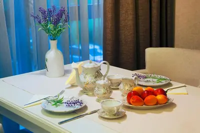a table with plates of fruit and a vase with flowers at VIKO Boutique Apart Hotel in Sofia