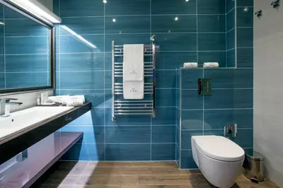 a blue bathroom with a toilet and a sink at VIKO Boutique Apart Hotel in Sofia