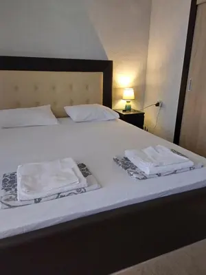 a bed with two white towels on top of it at Vila Nova in Sandanski