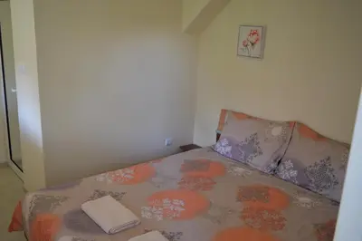 a small bedroom with a bed with a blanket and pillows at Guest House Vasilena Самостоятелно наемане FREE PARKING in Sapareva Banya
