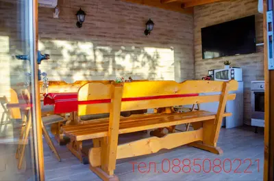 a dining room with a table and a bench at Guest House Vasilena Самостоятелно наемане FREE PARKING in Sapareva Banya