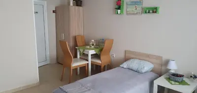 a bedroom with a bed and a table with chairs at Rooms Lagat in Troyan