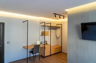 a room with a desk and a table with a chair at Family Hotel Pak Tam in Karlovo
