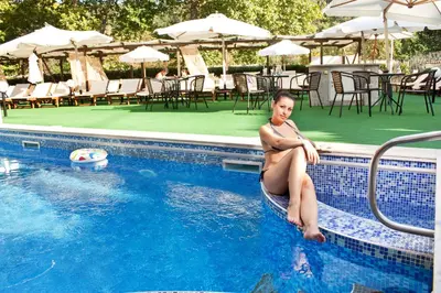 a woman in a bathing suit sitting in a swimming pool at Balneo Complex & Spa Aquatonik in Velingrad