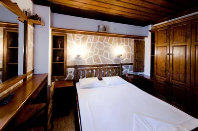 a bedroom with a bed and two lights on the wall at Petko Takov's House in Smolyan