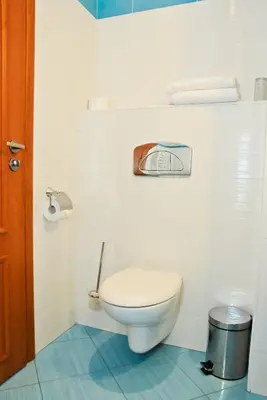 a bathroom with a toilet in a white wall at Hotel Astra in Sofia