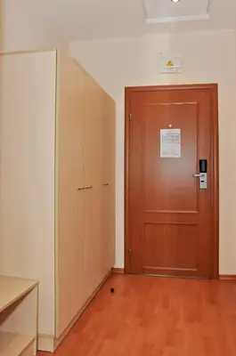 a room with a wooden door and a wooden floor at Hotel Astra in Sofia