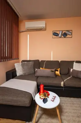 a living room with a couch and a table at MIDAS - Borov Park in Velingrad