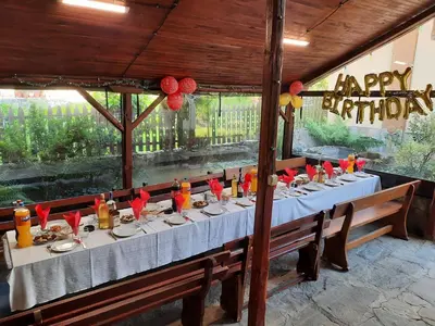 a long table in a restaurant with a happy birthday sign at Guest House Lazar Raykov in Ribarica
