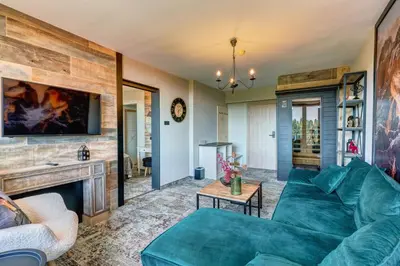 a living room with a blue couch and a fireplace at Grand Hotel Murgavets in Pamporovo