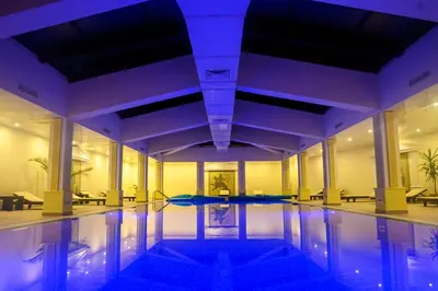 a swimming pool in a building with purple lighting at Parklands Hotel & Pool in Bansko