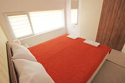 a bedroom with a bed with a red carpet at Lilly Apartments in Plovdiv