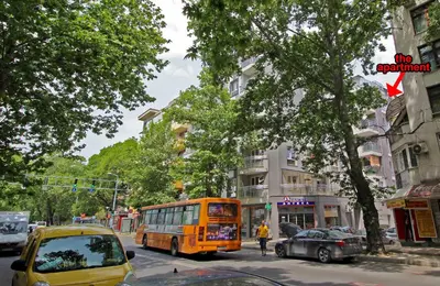an orange bus driving down a city street with cars at Lilly Apartments in Plovdiv