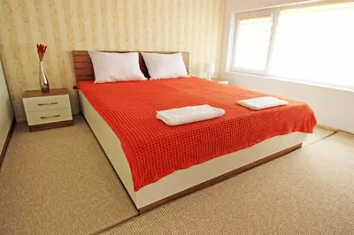 a bedroom with a large bed with two towels on it at Lilly Apartments in Plovdiv