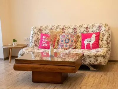 a living room with a couch with pillows and a table at Ma-Bebe SPA Suite - Thermal Jacuzzi and Family Comfort in Pchelin